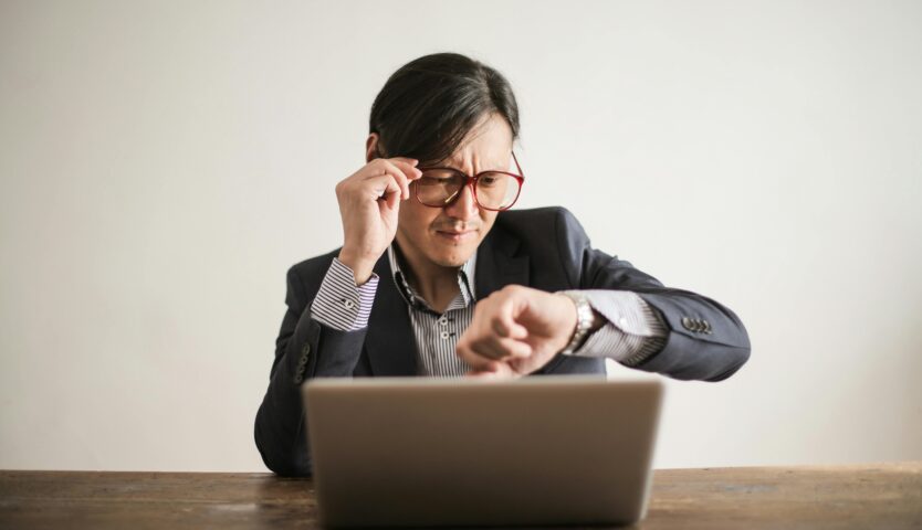 Man checking his watch, emphasizing the importance of meeting corporate tax filing deadlines